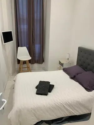 a bedroom with a bed with two pillows on it at Gustave in Nice