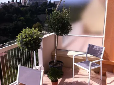 a balcony with two chairs and a potted plant at La Madonette in Nice