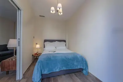 a bedroom with a bed with a blue blanket at 100m from the sea in Nice