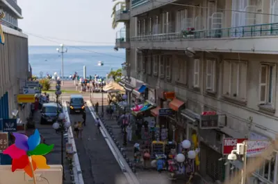 a view of a street with a building and a beach at 100m from the sea in Nice
