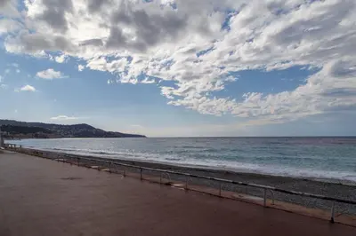 a beach with a cloudy sky and the ocean at 100m from the sea in Nice