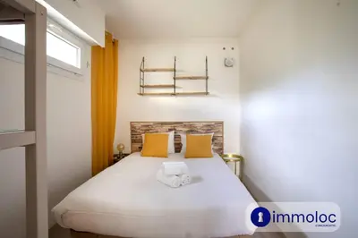 a bedroom with a large white bed with yellow pillows at Air-conditioned house with private pool in Cagnes-sur-Mer
