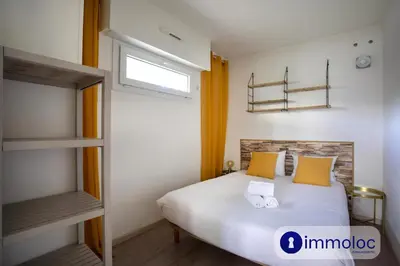 a bedroom with a bed with yellow pillows and a window at Air-conditioned house with private pool in Cagnes-sur-Mer