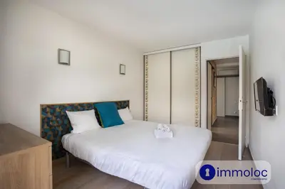 a bedroom with a white bed and a tv at Air-conditioned house with private pool in Cagnes-sur-Mer