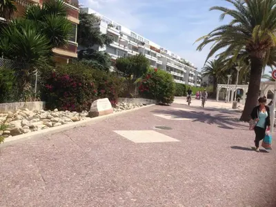 a group of people walking down a street with a building at MAEVA in Saint-Laurent-du-Var