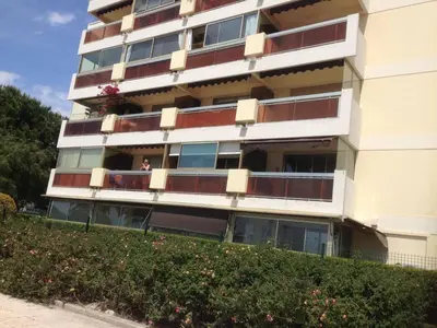 a tall apartment building with a person on the balcony at MAEVA in Saint-Laurent-du-Var