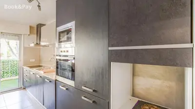 a kitchen with gray walls and stainless steel appliances at La Providence in Nice