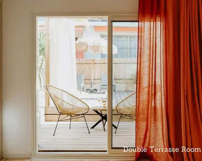 a sliding glass door to a patio with a table and chairs at Palm Boutique Hôtel Nice in Nice