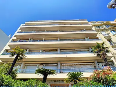 a tall white building with palm trees in front of it at Nestor&Jeeves - HORIZON PROMENADE - Central - Sea front in Nice