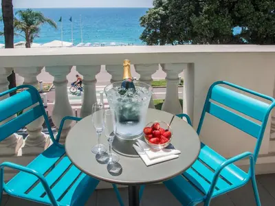 a table with a bottle of wine and a bowl of fruit at Mercure Nice Marché Aux Fleurs in Nice