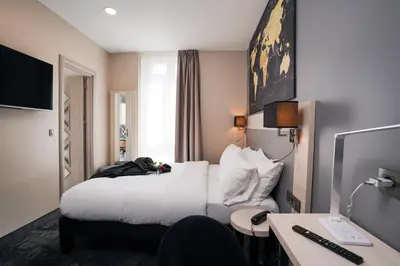 a hotel room with a bed and a desk at Hôtel Univers in Nice