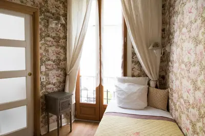 a small bedroom with a bed with a window at Hotel Villa Rivoli in Nice
