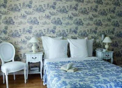a bedroom with a bed with a book and a chair at Hotel Villa Rivoli in Nice
