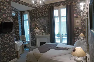 a bedroom with a large bed and a fireplace at Hotel Villa Rivoli in Nice