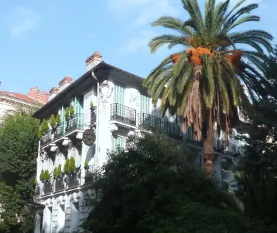 a building with a palm tree in front of it at Hotel Villa Rivoli in Nice