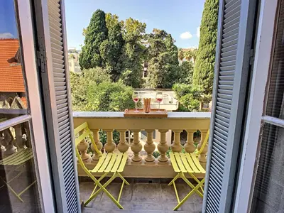 a balcony with chairs and a table and trees at Nestor&Jeeves - ANGEL'S BAY - City center - Close beaches in Nice