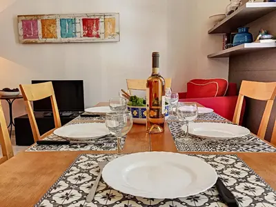 a table with white plates and a bottle of wine at Nestor&Jeeves - DALPOZZO GRANDE - Central - Close beaches in Nice