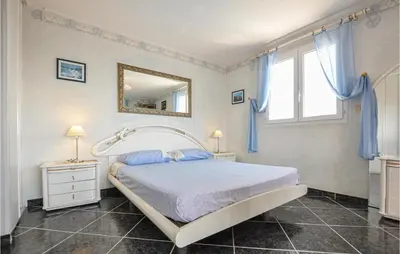 a bedroom with a bed and a mirror on the wall at Amazing Home In Cagnes Sur Mer in Cagnes-sur-Mer