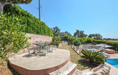 a patio with a table and chairs next to a pool at Amazing Home In Cagnes Sur Mer in Cagnes-sur-Mer