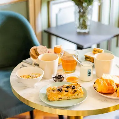 a table with plates of breakfast foods on it at Hôtel Vendôme in Nice