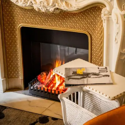 a fireplace in a living room with a fire at Hôtel Vendôme in Nice