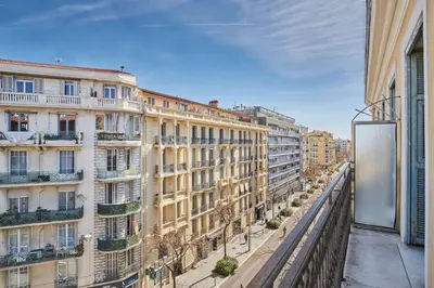 a white bedroom with a bed and a mirror at Appart'hôtel Odalys City - Nice Centre in Nice