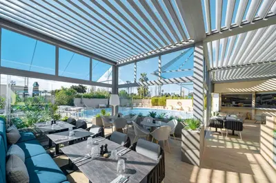a restaurant with tables and chairs and large windows at Radisson Hotel Nice Airport in Nice