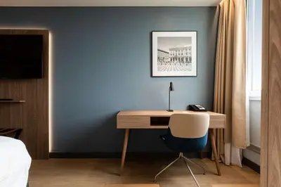 a desk in a bedroom with a blue wall at Radisson Hotel Nice Airport in Nice