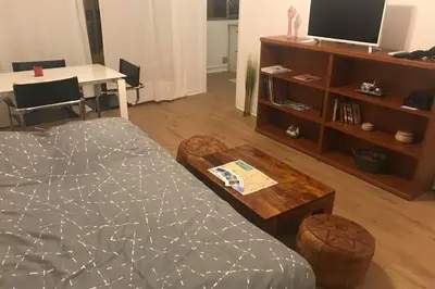 a living room with a bed and a table and a desk at studio centre nice proche de mer in Nice
