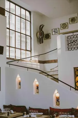 a dining room with stairs and tables and chairs at HOTEL AMOUR NICE in Nice