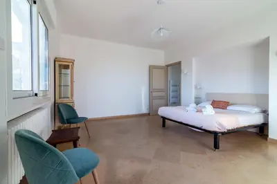 a bedroom with a bed and two chairs and a window at Villa Primavera Splendid villa with sea view in Saint-Jean Cap Ferrat in Saint-Jean-Cap-Ferrat