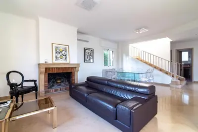 a living room with a leather couch and a fireplace at Villa Primavera Splendid villa with sea view in Saint-Jean Cap Ferrat in Saint-Jean-Cap-Ferrat