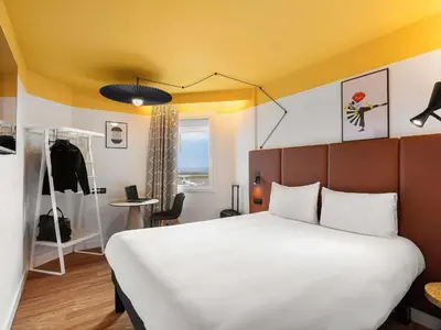 a bedroom with a white bed and a yellow ceiling at ibis Nice Aéroport Promenade des Anglais in Nice