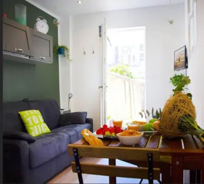 a living room with a table with a bowl of fruit at LE REFUGE avec terrasse et jardin, en plein centre-ville, gare 5 minutes à pieds in Nice