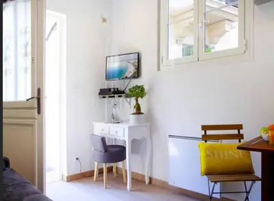 a room with a desk with a tv and a chair at LE REFUGE avec terrasse et jardin, en plein centre-ville, gare 5 minutes à pieds in Nice