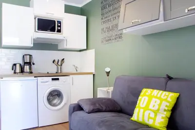 a living room with a couch and a washing machine at LE REFUGE avec terrasse et jardin, en plein centre-ville, gare 5 minutes à pieds in Nice