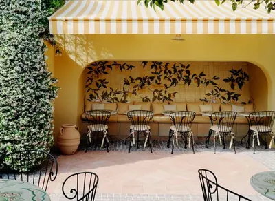a living room with a fireplace and a table and chairs at Hôtel La Pérouse Nice Baie des Anges in Nice