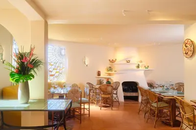 a living room with a couch with four chairs at Hôtel La Pérouse Nice Baie des Anges in Nice