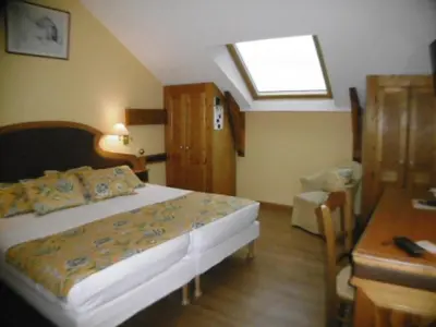 a bedroom with a bed and a desk and a window at Hôtel La Flore in Villefranche-sur-Mer
