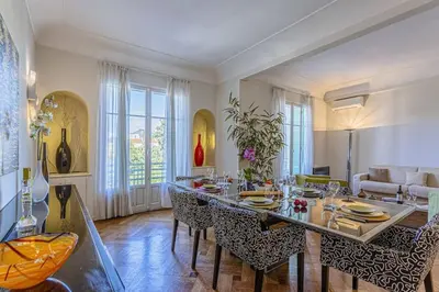 a living room with a long table and chairs at MY CASA - VICTOR HUGO - Beautiful Apartment - View over Garden in Nice