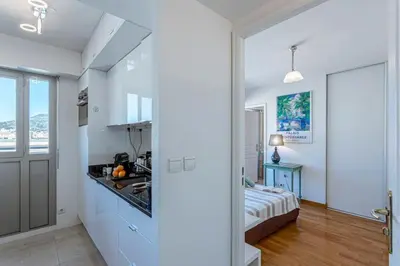 a white room with a kitchen and a bed at MY CASA - PALAIS MED - Palais Méditerranéen - Panoramic view in Nice