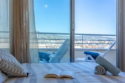 a bedroom with a bed with a book and chairs at MY CASA - PALAIS MED - Palais Méditerranéen - Panoramic view in Nice