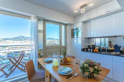 a kitchen and dining room with a table and a balcony at MY CASA - PALAIS MED - Palais Méditerranéen - Panoramic view in Nice