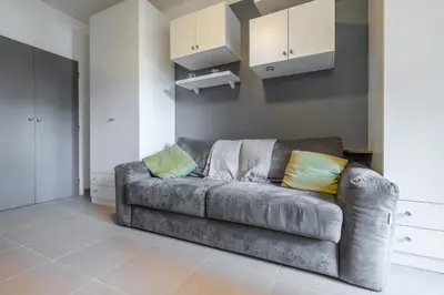 a grey couch in a living room with yellow pillows at Cosy Studio at Nice Port in Nice