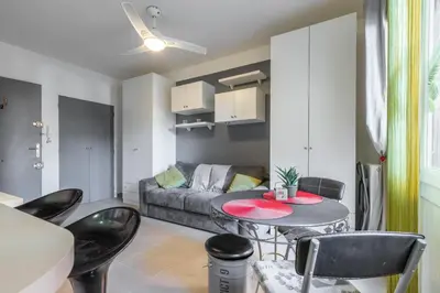 a living room with a couch and a table and chairs at Cosy Studio at Nice Port in Nice