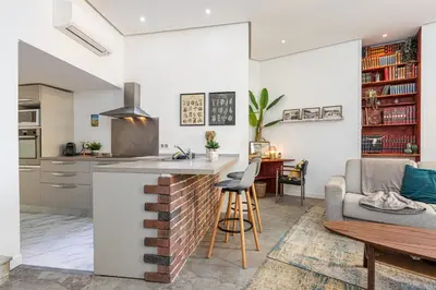 a kitchen and living room with a brick wall at Cosy Studio in the Old Town near Garibaldi Square in Nice