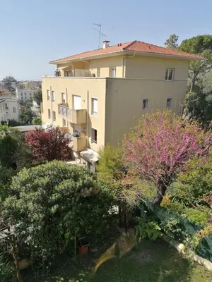 a view of a building with trees and bushes at Villa Soraya Nice - Sunny appartment Cote d'Azur with large garden in Nice