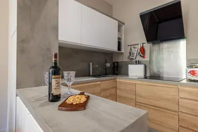 a bottle of wine and a glass on a counter in a kitchen at MY CASA - JOFFRE 49-D - Charming 2 bedroom - Carré d'Or in Nice