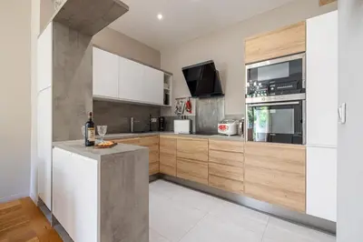 a kitchen with white and wooden cabinets and a counter at MY CASA - JOFFRE 49-D - Charming 2 bedroom - Carré d'Or in Nice