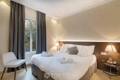 a bedroom with a large white bed and a chair at Villa Artemys - Five Stars Holiday House in Saint-Jean-Cap-Ferrat